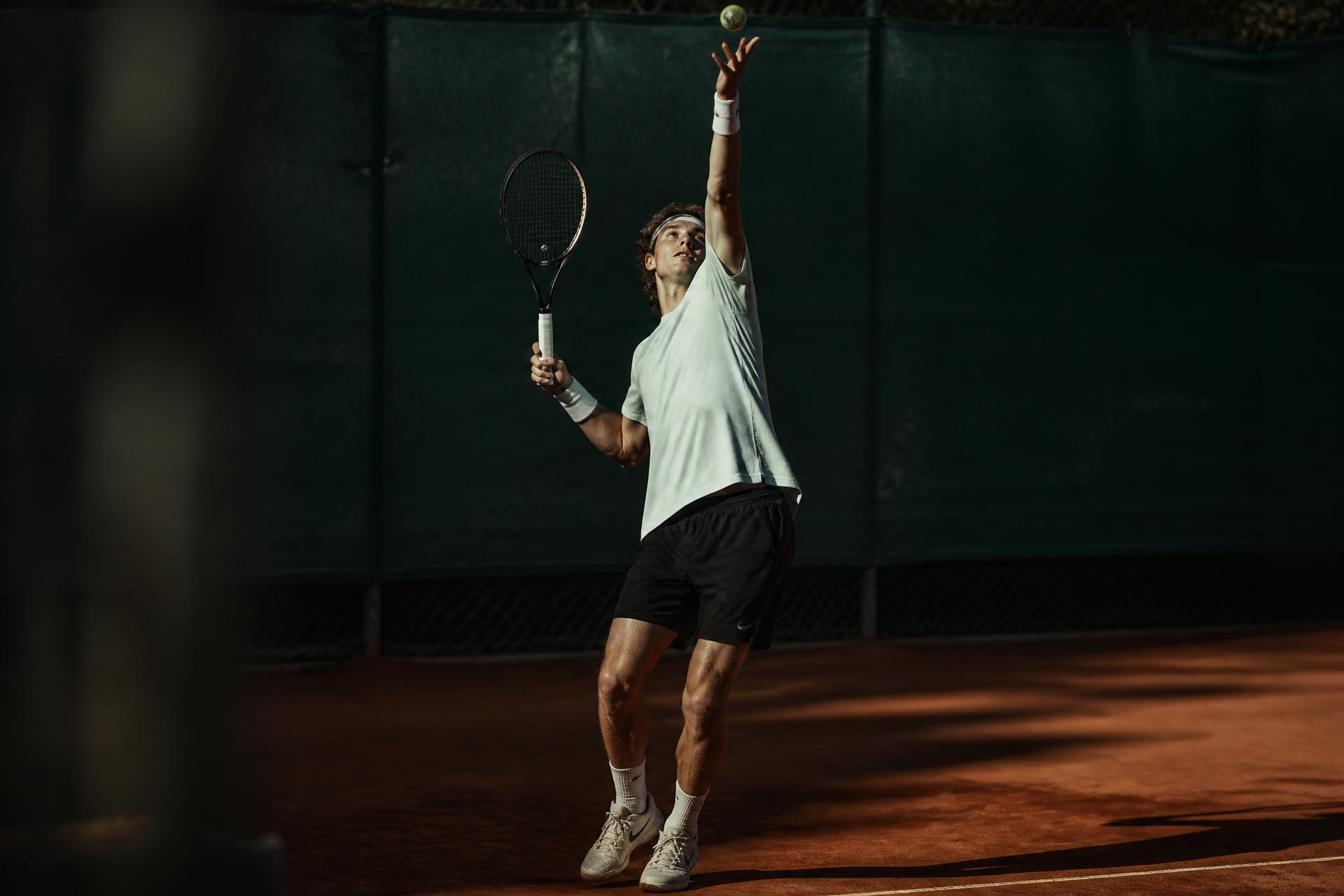 Tennisspieler beim Aufschlag auf dem Sandplatz